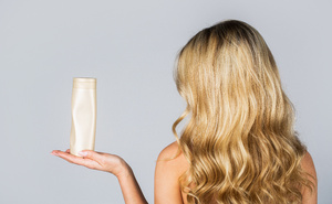 Frau mit Shampoo in der Hand Silikone und Sulfate: Warum sie nicht per se schlecht sind